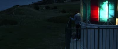 a man standing next to a metal fence at night