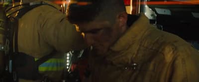 a man in a fireman's uniform is looking down