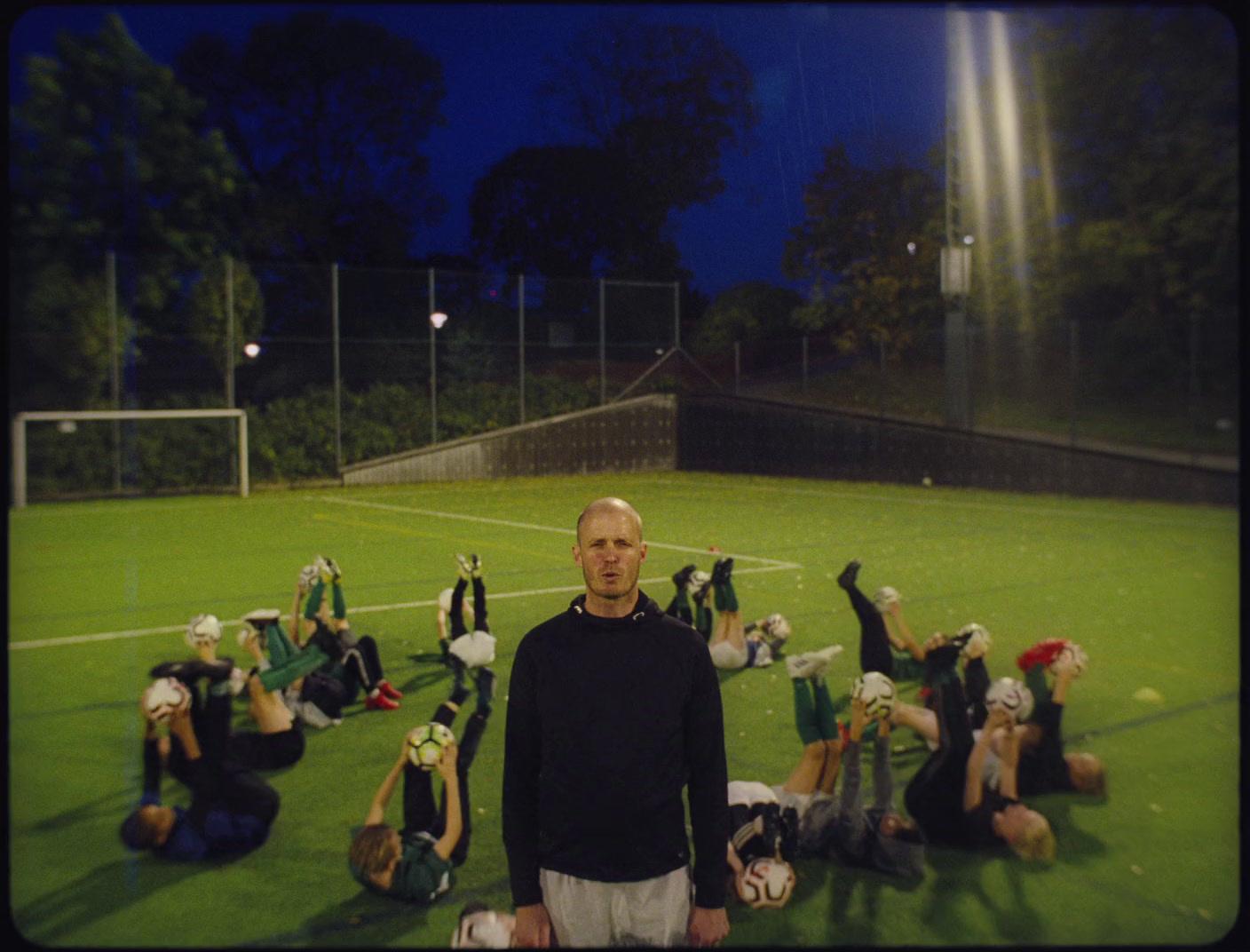 a man standing in front of a group of people on a soccer field