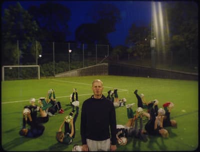 a man standing in front of a group of people on a soccer field