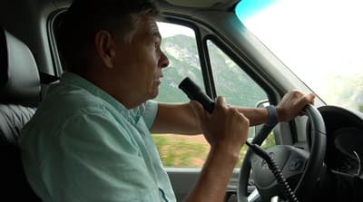 a man driving a truck on a cell phone