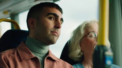 a man and a woman sitting on a bus