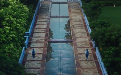 an aerial view of a pool surrounded by trees