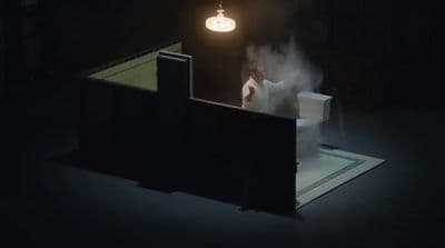 a person standing on a toilet in a dark room