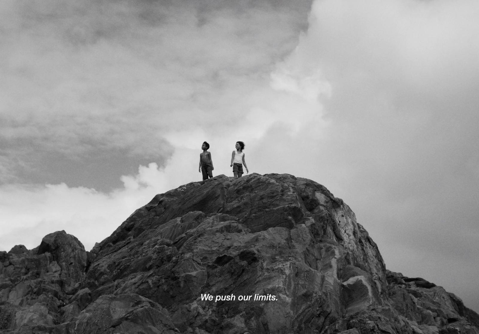 a couple of people standing on top of a mountain