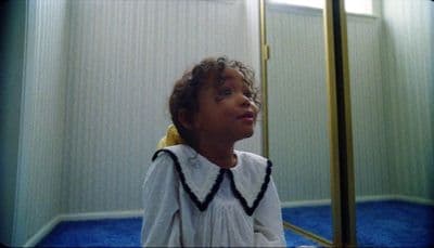 a little girl that is standing in front of a mirror