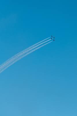 two airplanes flying in the sky leaving a trail of smoke behind them