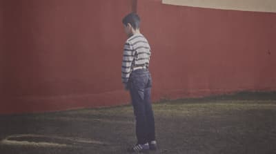 a man standing in front of a red wall