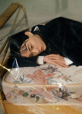 a woman laying on top of a bed in a room