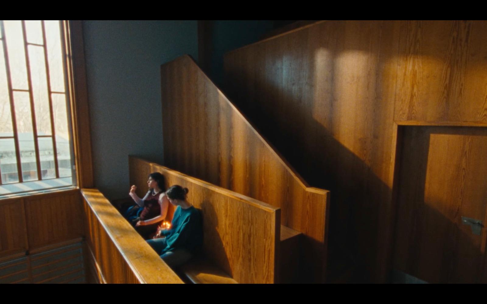 a couple of people sitting on top of a wooden bench