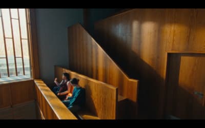 a couple of people sitting on top of a wooden bench