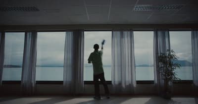a man standing in front of a window holding a brush
