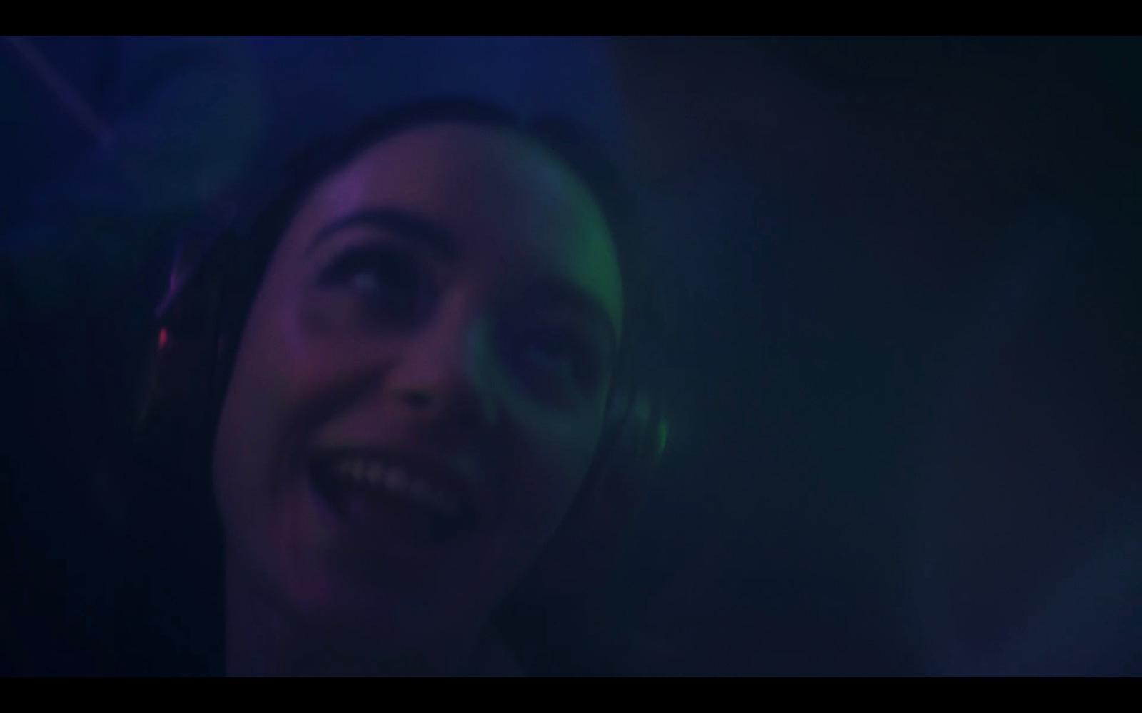 a woman wearing headphones in a dark room