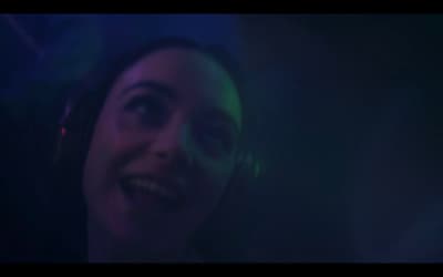 a woman wearing headphones in a dark room