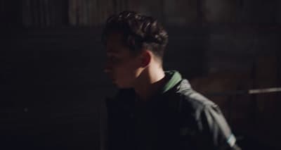 a man standing in a dark room with his head turned to the side