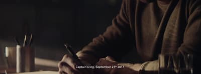 a man sitting at a table with a pen in his hand