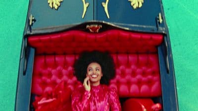a woman in a red dress sitting in a red couch