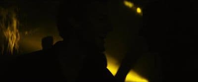 a man standing next to a woman in a dark room
