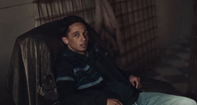 a man sitting in a chair in a jail cell