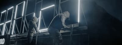 a couple of men standing on top of a ladder