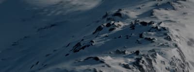 a snowboarder is going down a snowy mountain
