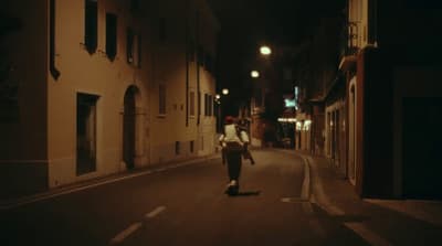a man walking down a street at night