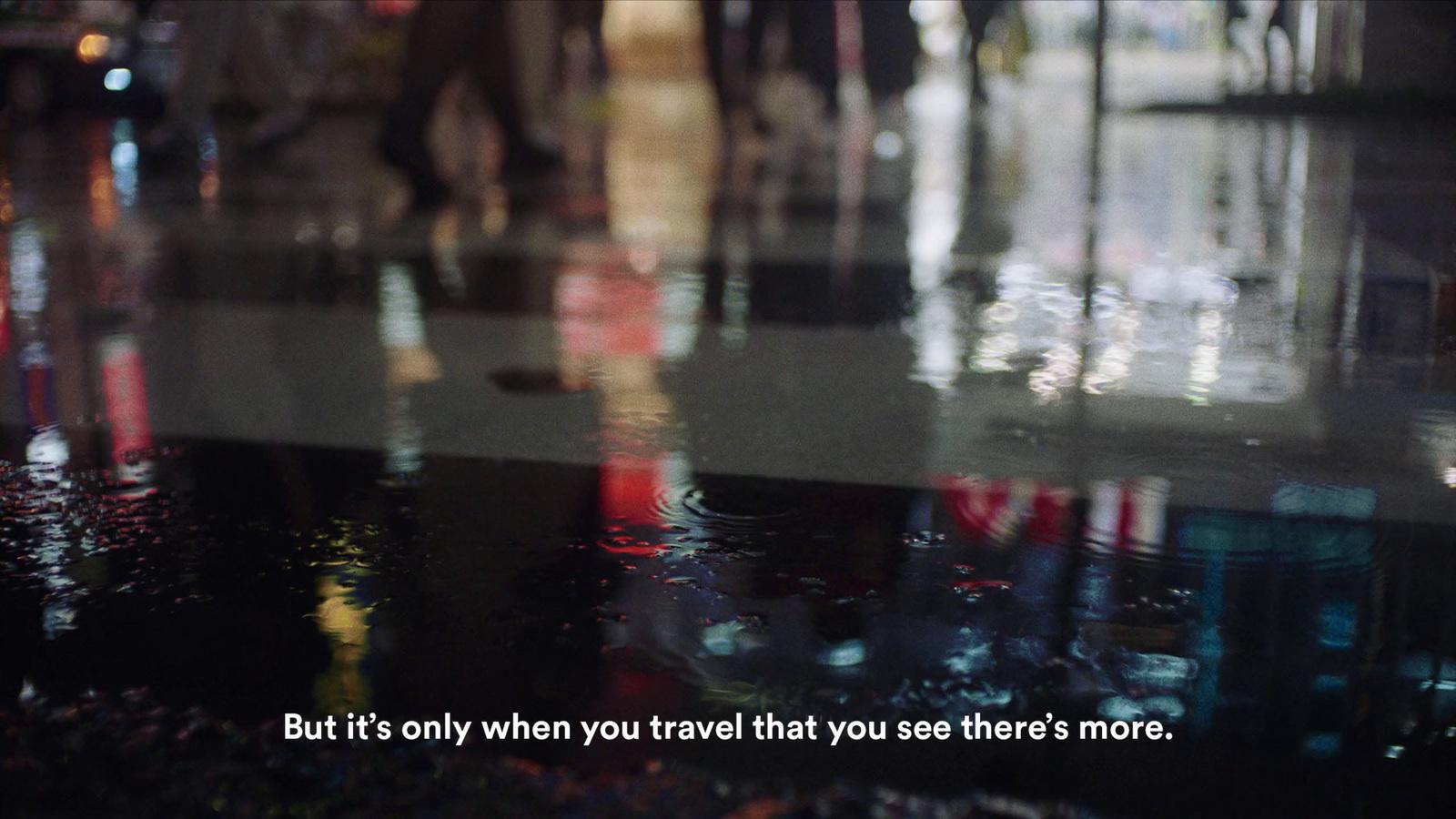 a picture of people walking down the street in the rain