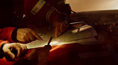 a man in a fireman's uniform writing on a piece of paper