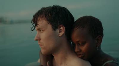 a man holding a woman on his back in the water