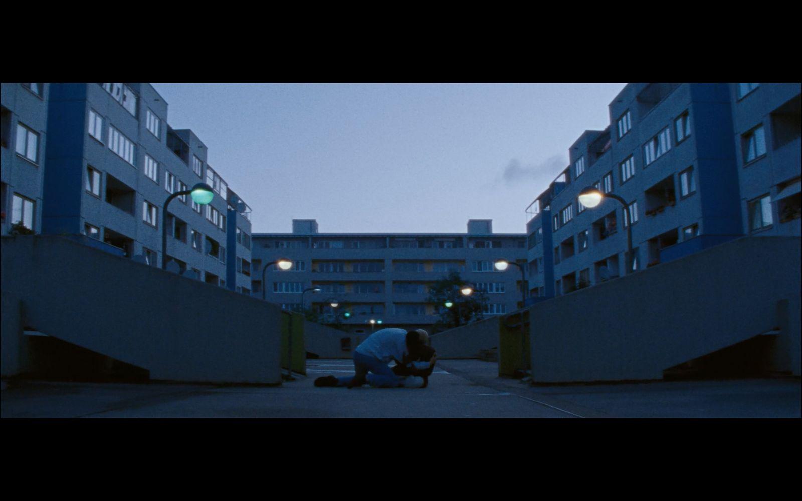 a person sitting on the ground in front of a building
