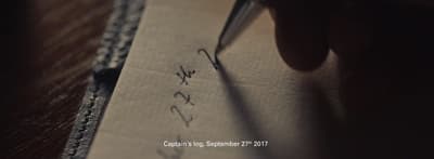 a person writing on a piece of paper with a pen