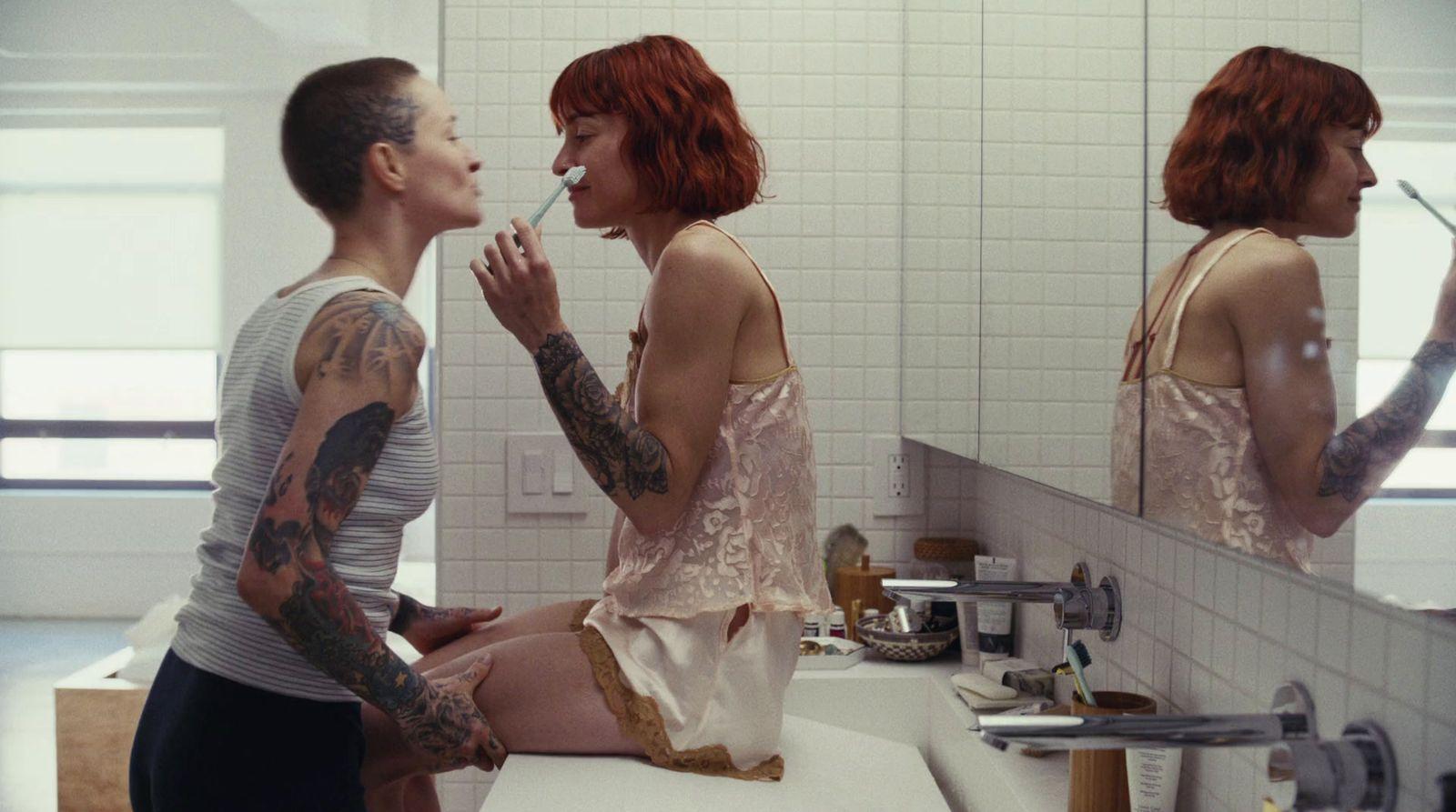 a man and a woman sitting in front of a bathroom mirror
