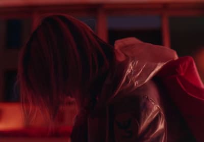 a woman in a leather jacket holding a red bag