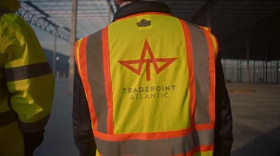 a man in a reflective vest is standing next to another man
