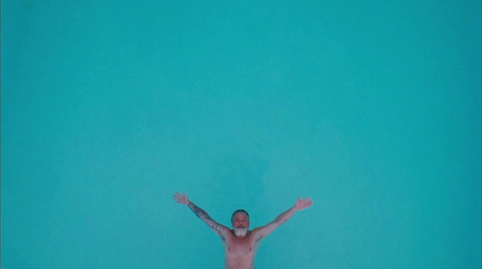 a man standing in the water with his arms outstretched