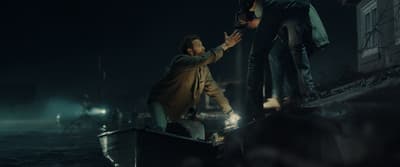 a man standing on top of a boat next to another man