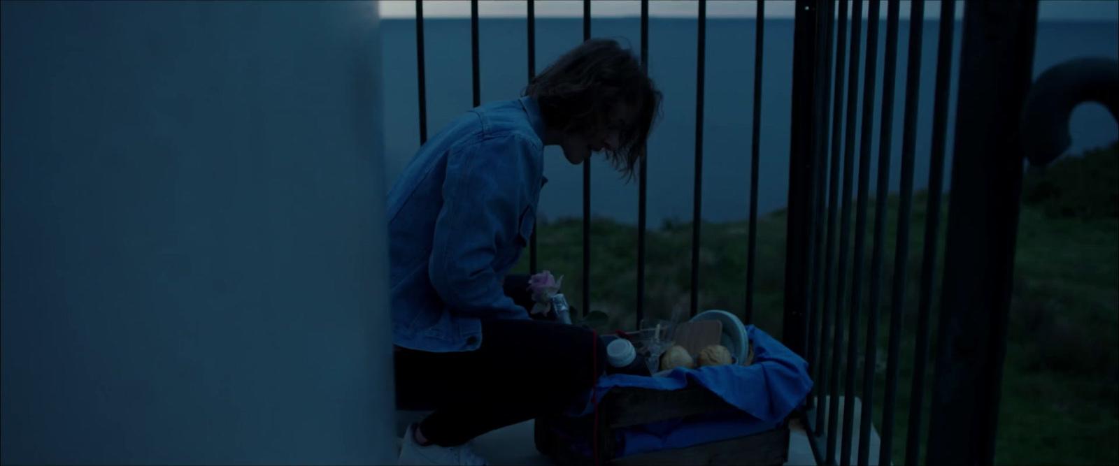 a woman standing next to a fence with a baby in a stroller