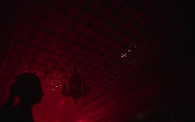 a person standing in a dark room with a red light