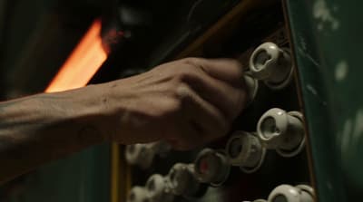 a person is working on a machine with a flame in the background