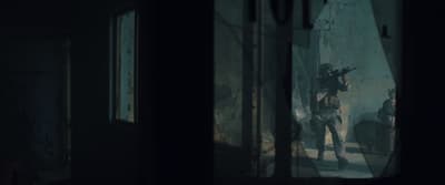 a man holding a gun in a dark room