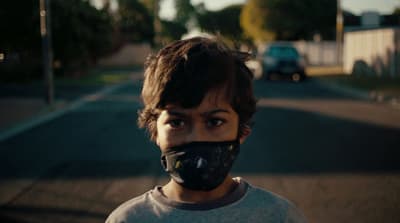 a young man wearing a mask on the street