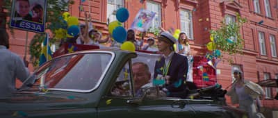 a group of people in a car with balloons and confetti