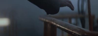 a hand reaching for something on a railing