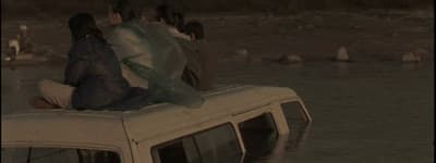 a group of people sitting on top of a van in the water