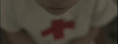 a blurry photo of a young boy with a red cross on his shirt