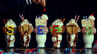 a row of ice cream cones with candy toppings