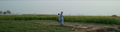 a woman in a blue dress standing in a field