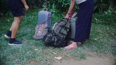 a couple of people standing next to a pile of luggage