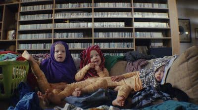 a couple of kids sitting on top of a couch