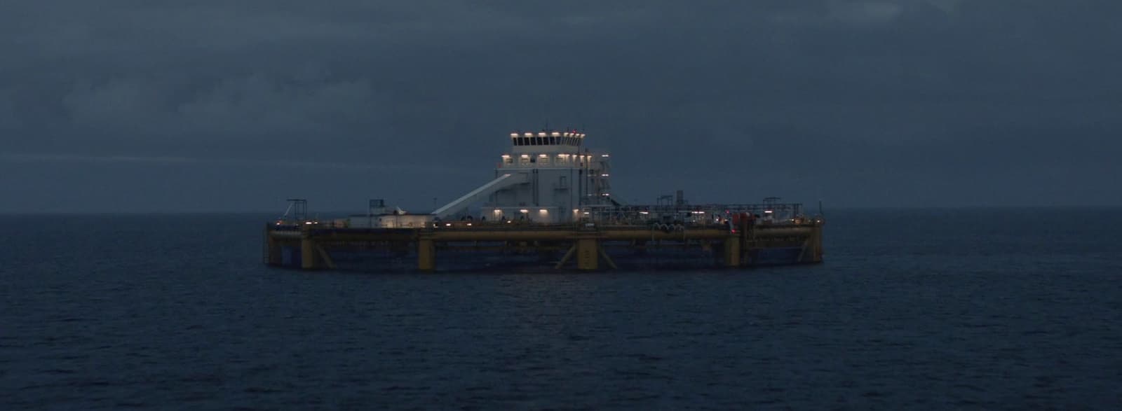 an oil rig in the middle of the ocean at night